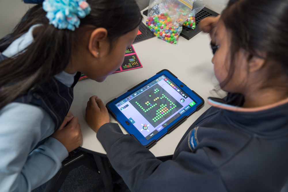 Photo of two primary school girls looking at an iPad.