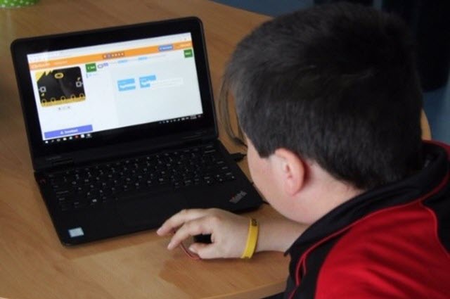 Photo of a boy in a red top using the BBC Microbit website