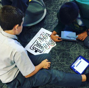 Kids sitting on the floor programming